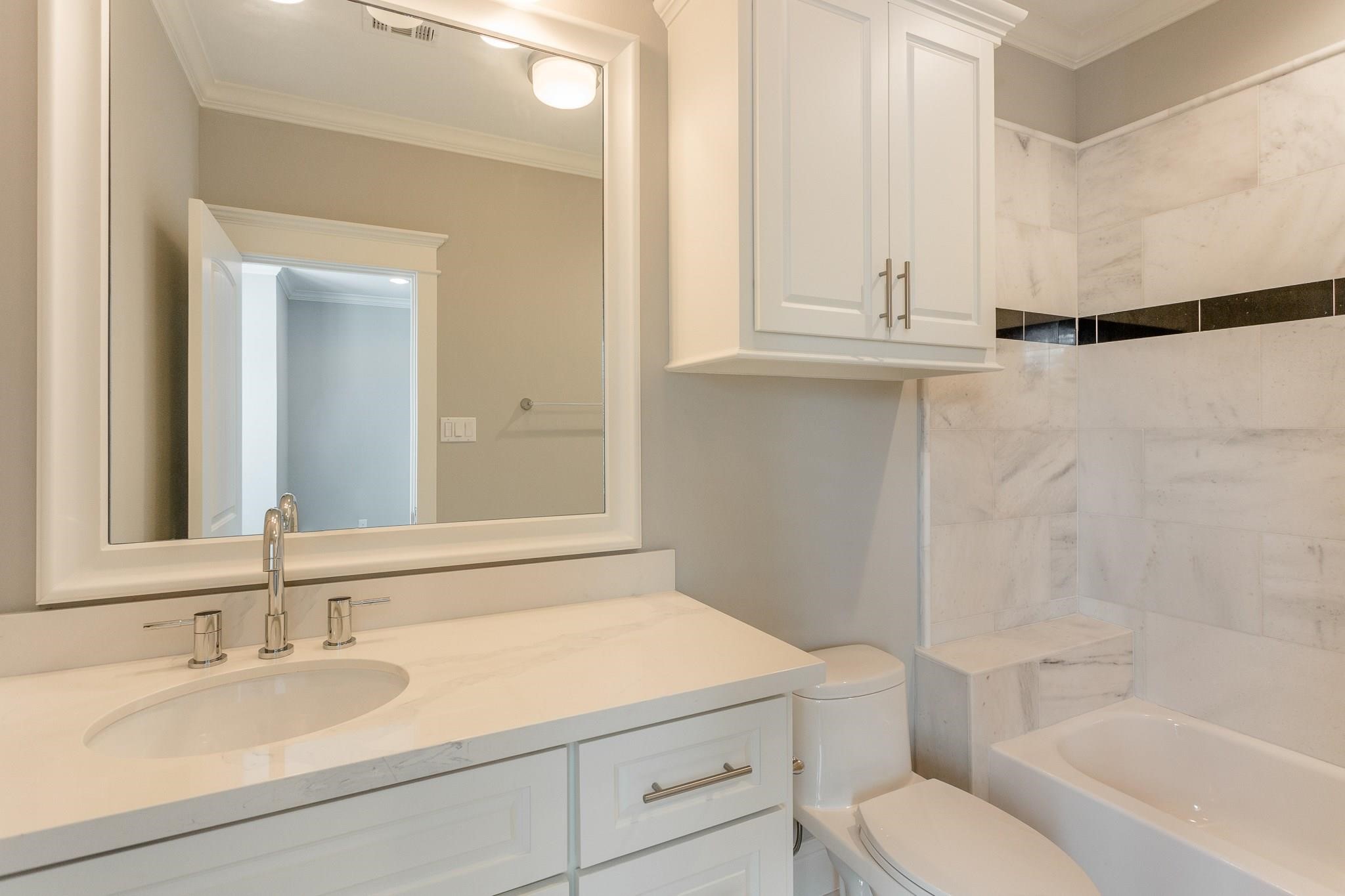2035 Sheridan Street, Unit A Houston, TX 77030 - Photo 26 of 41 a bathroom with a granite countertop sink toilet and shower