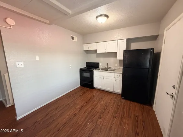 a kitchen with a refrigerator and white cabinets