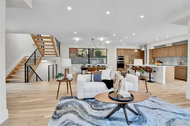 a living room with furniture a wooden floor and a kitchen view