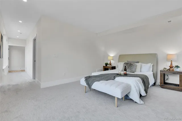 a spacious bedroom with a bed and a lamp