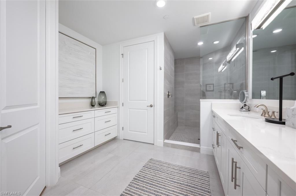 16360 Viansa Way, Unit 8201 Naples, FL 34110 - Photo 15 of 35 a spacious bathroom with a double vanity sink a mirror and a shower