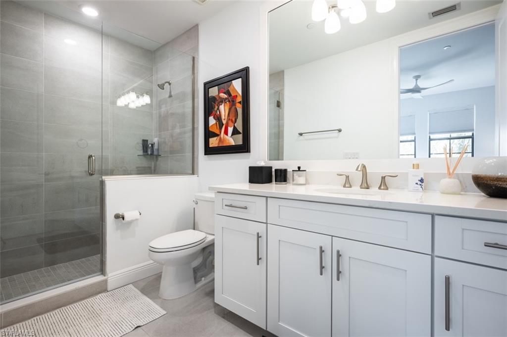 16360 Viansa Way, Unit 8201 Naples, FL 34110 - Photo 27 of 35 a bathroom with a toilet sink and mirror