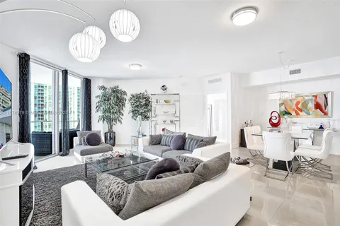 a living room with furniture chandelier and a large window