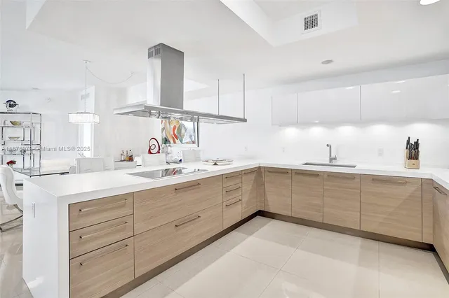 a kitchen with kitchen island stainless steel appliances a sink and cabinets