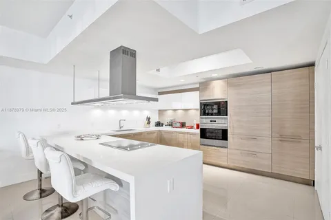 a kitchen with a table chairs refrigerator and cabinets