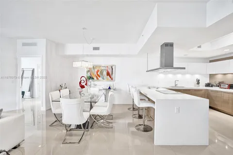 a white kitchen with a stove a table and chairs