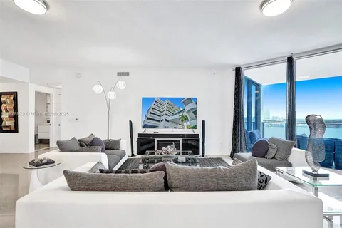a living room with fireplace furniture and a large window