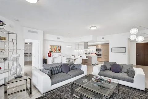 a living room with furniture and a view of kitchen