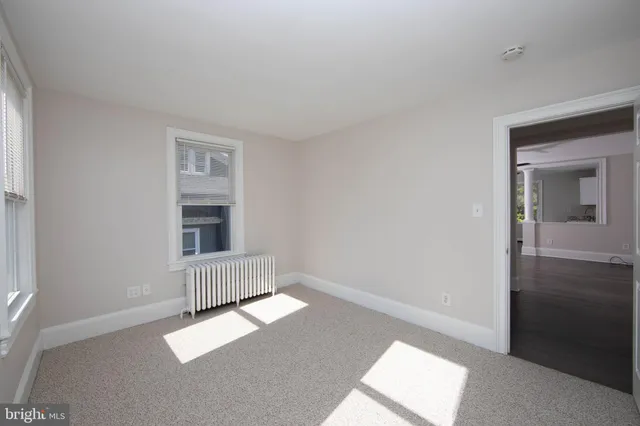 an empty room with a window and wooden floor