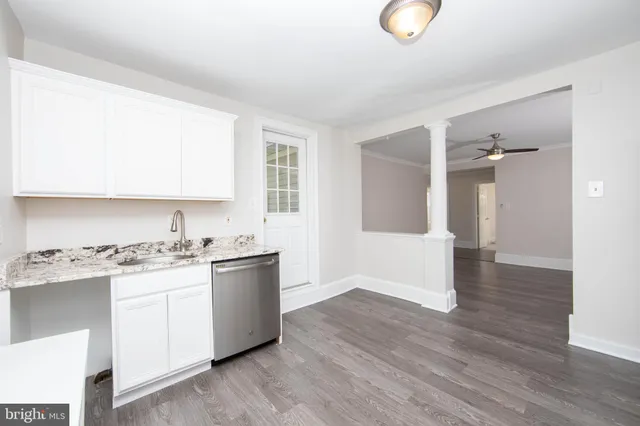 a kitchen with a sink cabinets and wooden floor