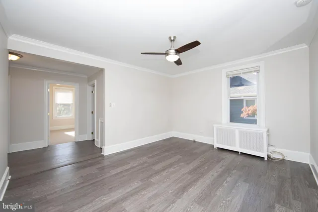 a view of a livingroom with wooden floor and a ceiling fan