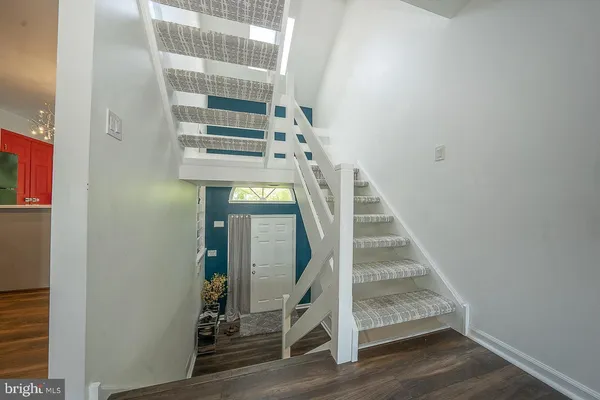 a view of staircase with wooden floor and white walls