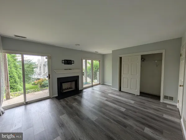 a view of a livingroom with wooden floor a fireplace and window