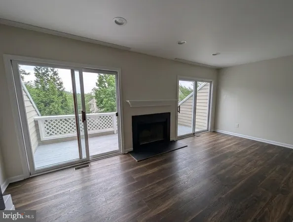 a view of a livingroom with wooden floor and a fireplace