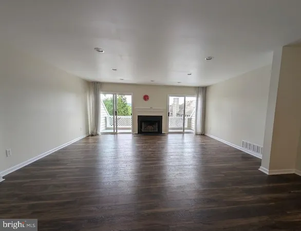 an empty room with wooden floor and fireplace