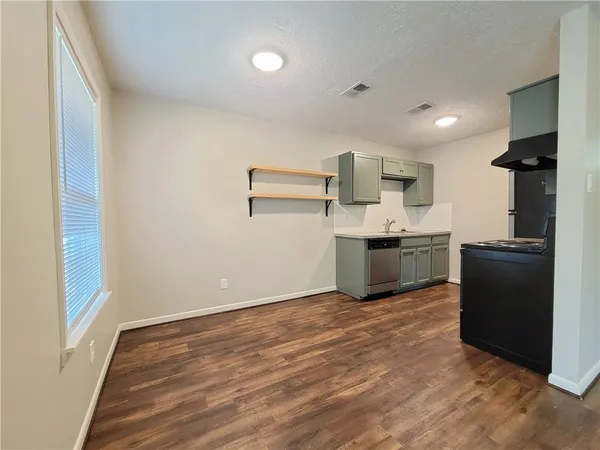 a view of kitchen with stainless steel appliances granite countertop a refrigerator and a sink