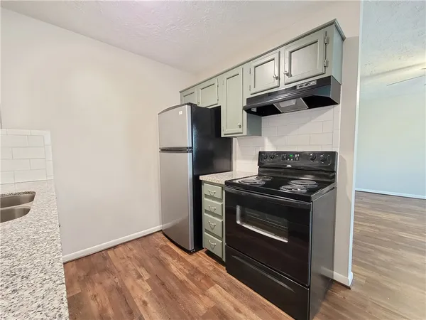 a kitchen with stainless steel appliances granite countertop a stove and a refrigerator