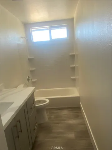 a bathroom with a bathtub sink vanity and a toilet