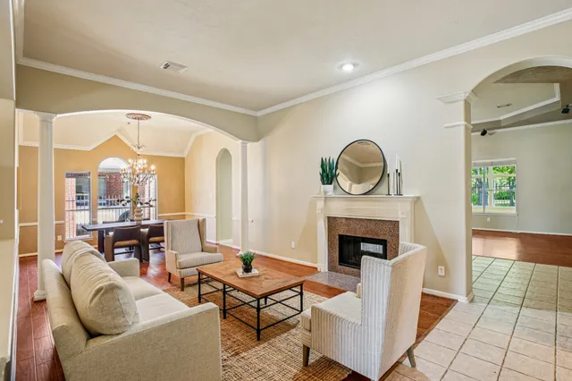 a living room with furniture a fireplace and a floor to ceiling window