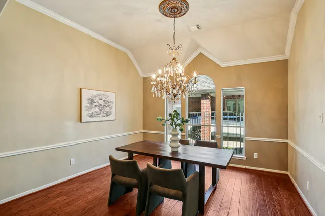 a view of a dining room with furniture wooden floor and chandelier