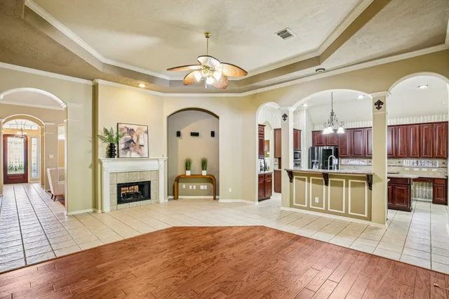 a open kitchen with furniture a fireplace and a chandelier