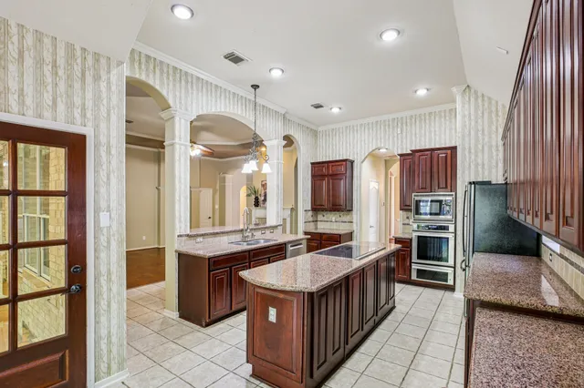 a kitchen with stainless steel appliances granite countertop a stove and a refrigerator