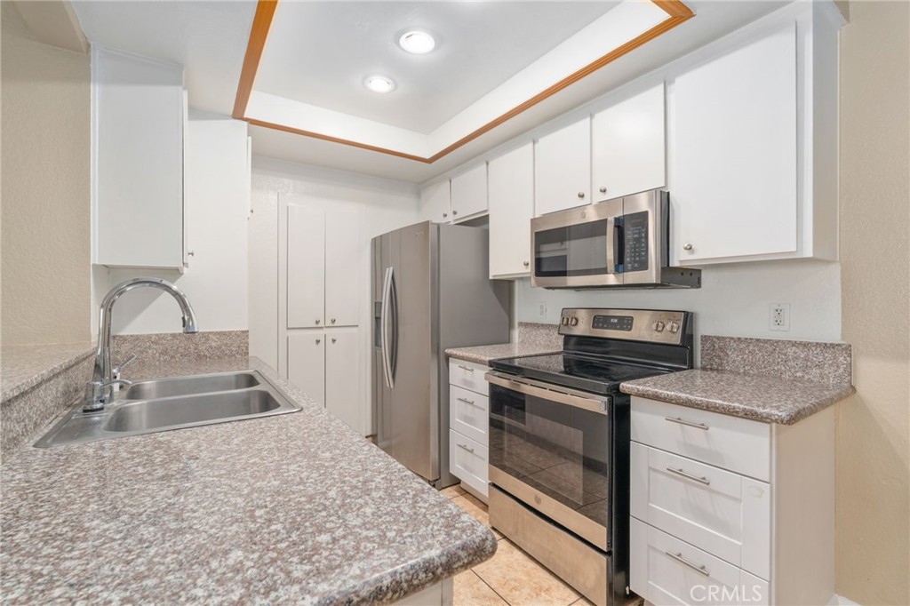 3535 Banbury Drive, Unit 119 Riverside, CA 92505 - Photo 9 of 23 a kitchen with stainless steel appliances granite countertop a stove a sink and a refrigerator