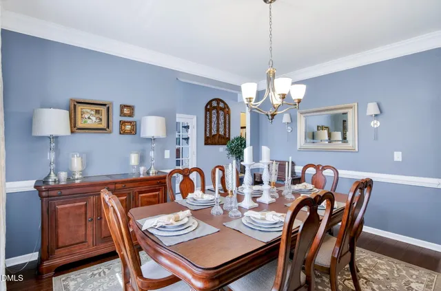 a living room with furniture a fireplace and a chandelier