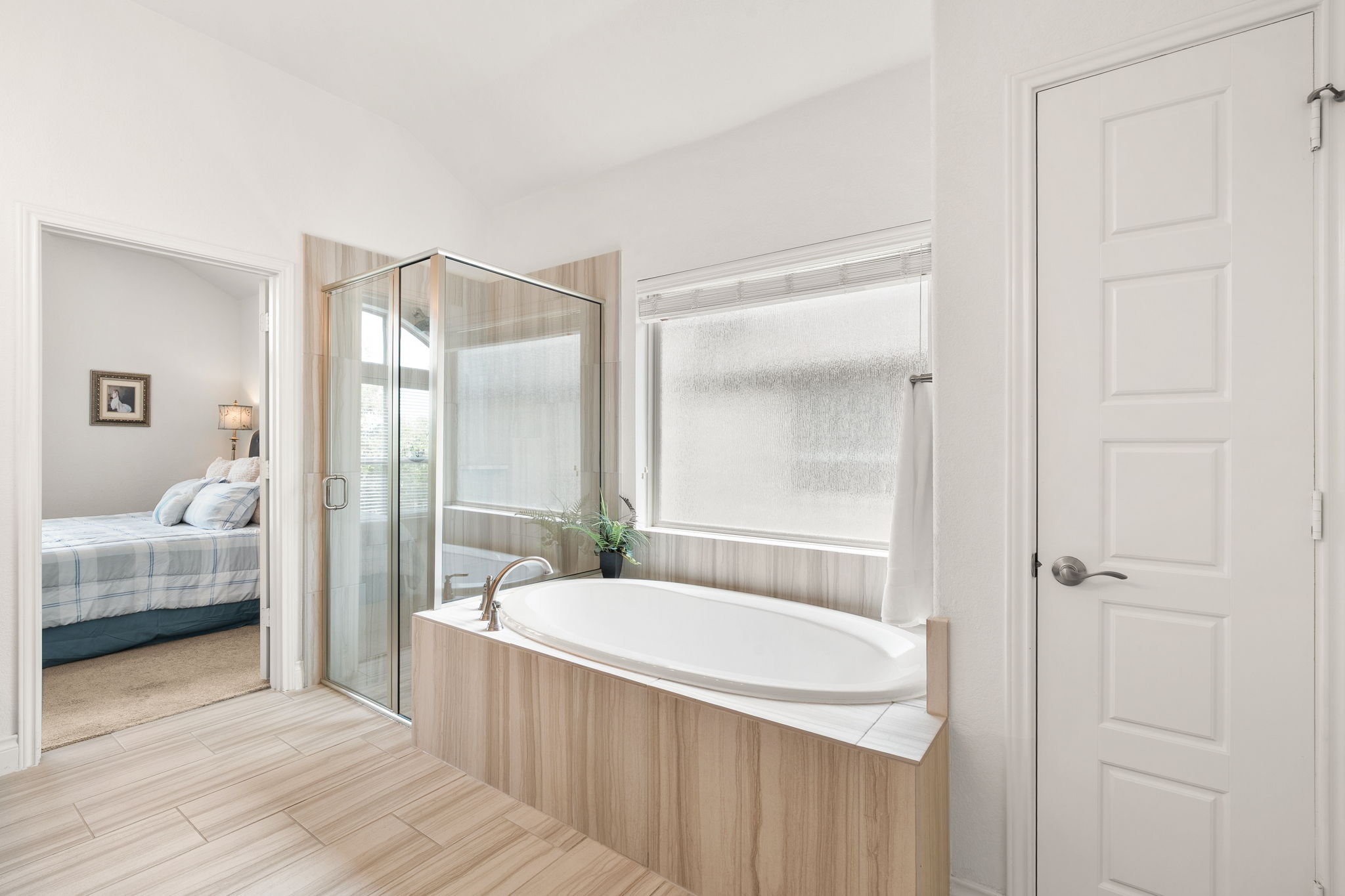 1908 Woolsey Way Leander, TX 78641 - Photo 13 of 36 Indulge in a relaxing soak in this modern bathroom featuring a deep tub and glass-enclosed shower.