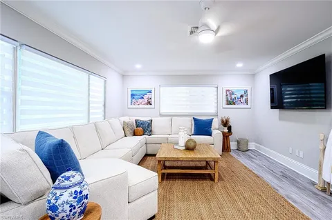 a living room with furniture a flat screen tv and a window