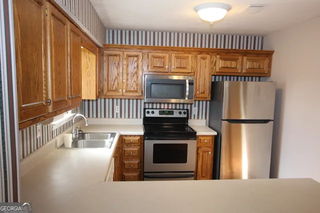 a kitchen with windows and a refrigerator