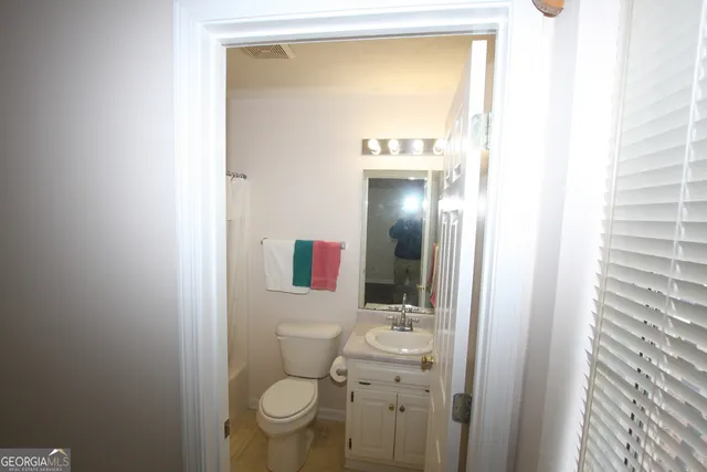 a bathroom with a sink a toilet and shower curtain