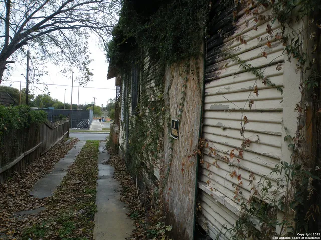 a view of a yard with wooden fence