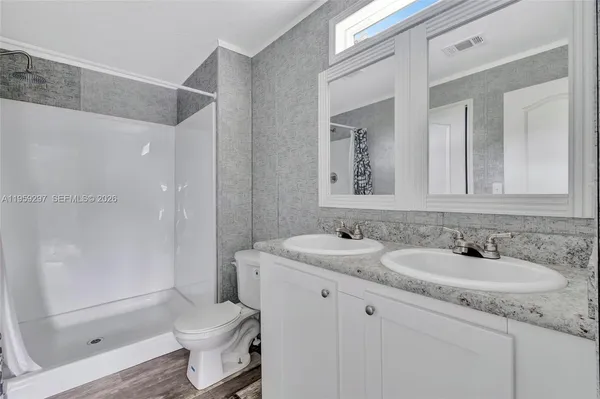 a bathroom with a granite countertop sink toilet and shower