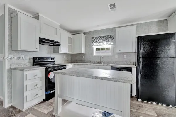 a kitchen with granite countertop a sink stove and refrigerator
