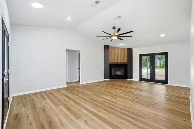a view of an empty room with a fireplace and a window