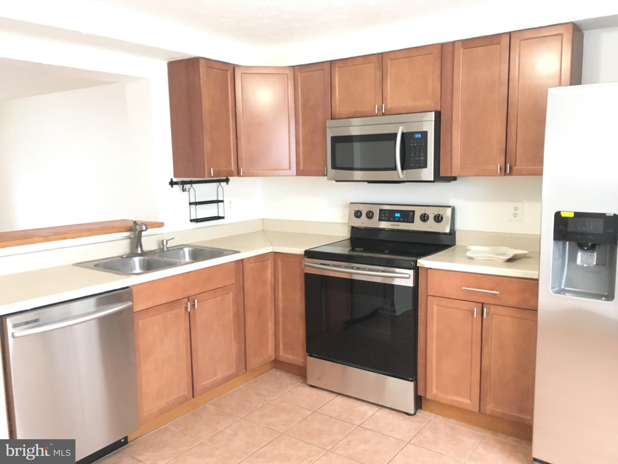 6944 Villa-Del-Rey Court Springfield, VA 22150 - Photo 3 of 14 a kitchen with stainless steel appliances granite countertop a stove microwave and sink
