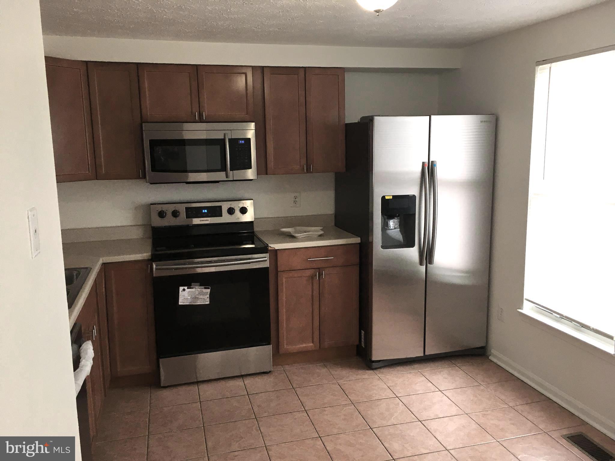 6944 Villa-Del-Rey Court Springfield, VA 22150 - Photo 4 of 14 a kitchen with stainless steel appliances granite countertop a refrigerator and a stove top oven