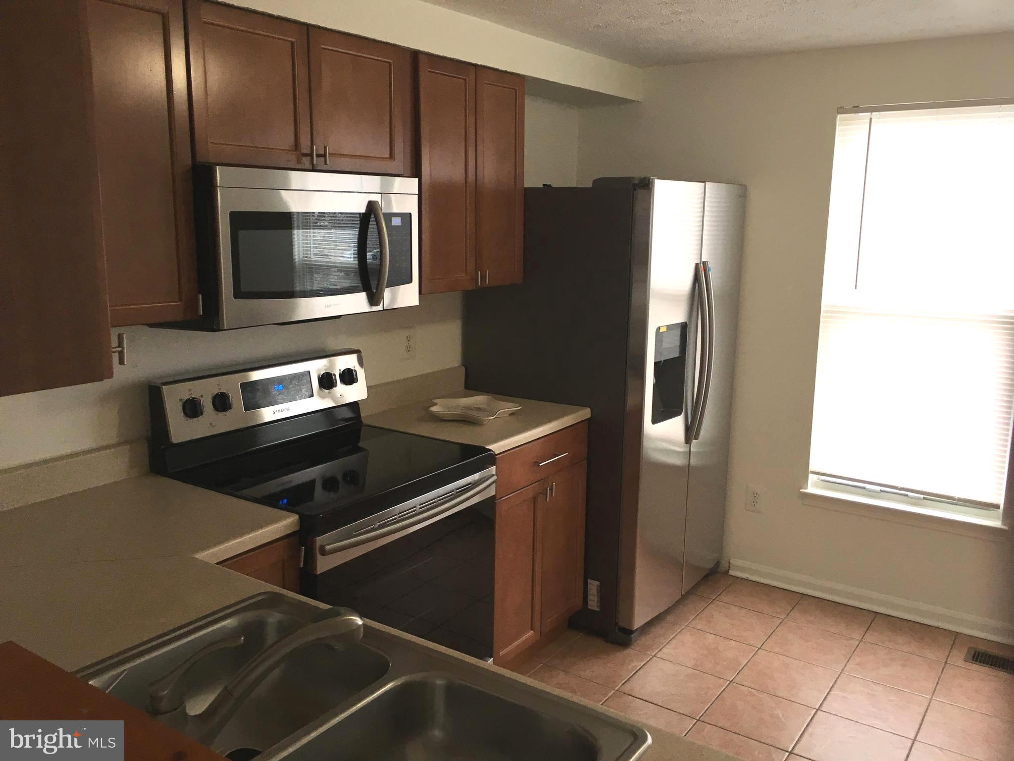 6944 Villa-Del-Rey Court Springfield, VA 22150 - Photo 5 of 14 a kitchen with a refrigerator stove and microwave