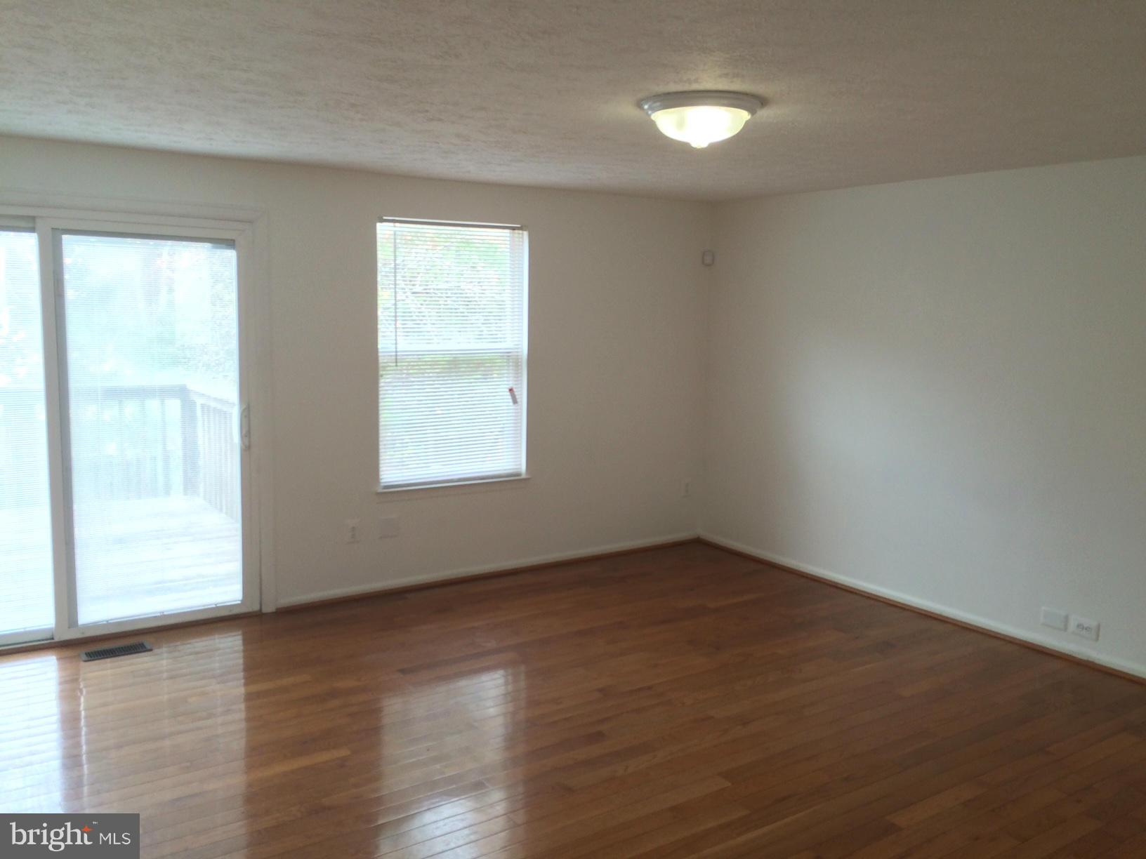6944 Villa-Del-Rey Court Springfield, VA 22150 - Photo 6 of 14 an empty room with wooden floor and windows