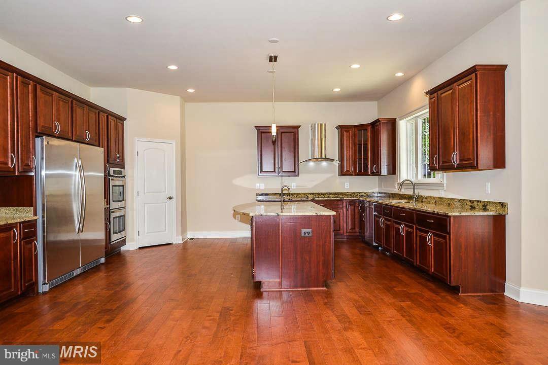 8536 Old Keene Mill Road Springfield, VA 22152 - Photo 4 of 30 a kitchen with stainless steel appliances granite countertop a refrigerator a sink dishwasher a stove with wooden cabinets and floor