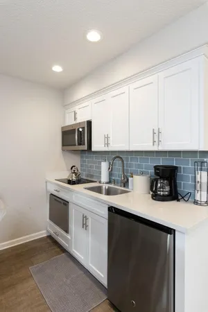 a kitchen with stainless steel appliances granite countertop a stove a sink and a microwave