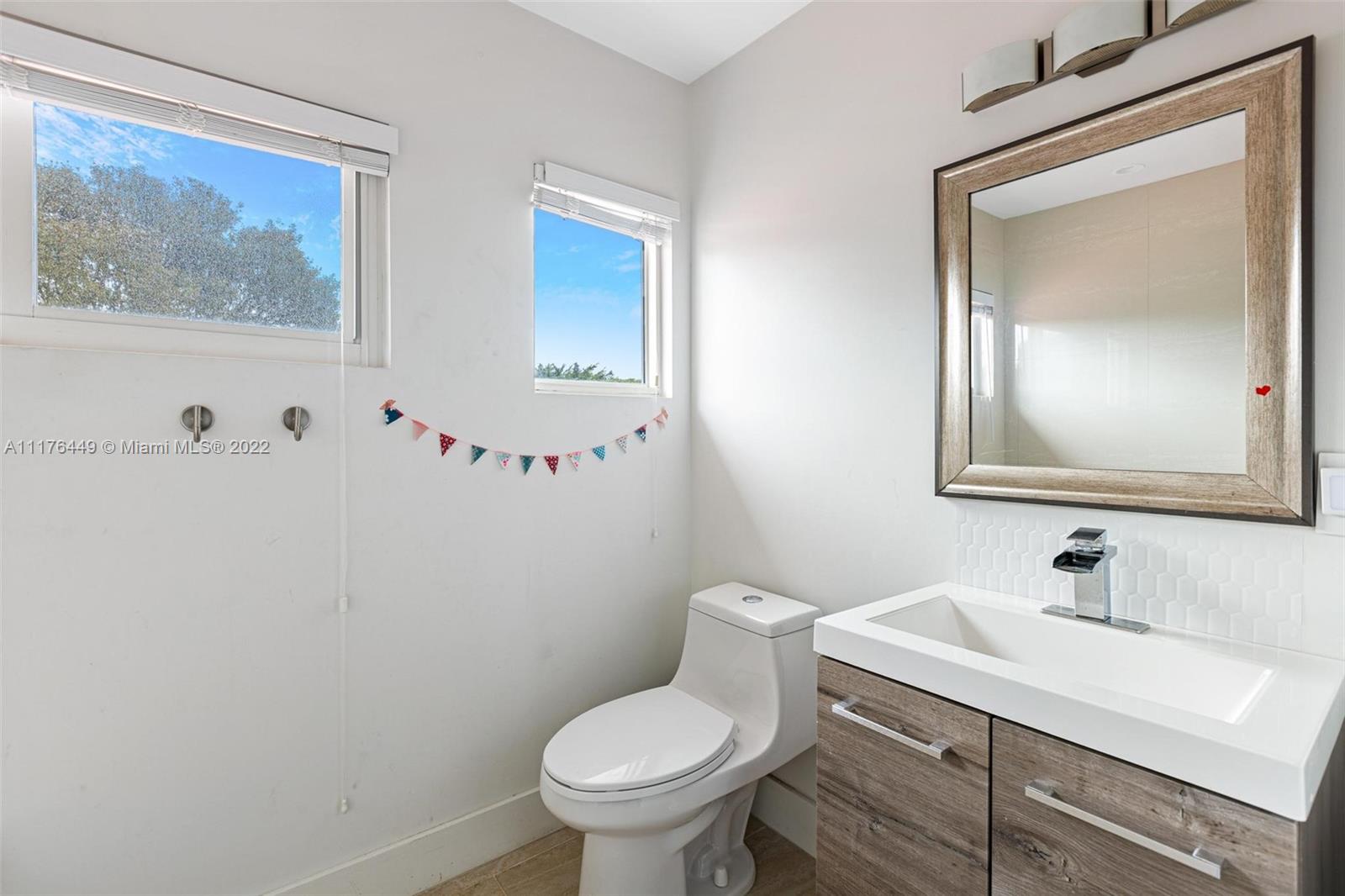 1910 Coral Gate Drive Miami, FL 33145 - Photo 22 of 39 a bathroom with a toilet sink and mirror