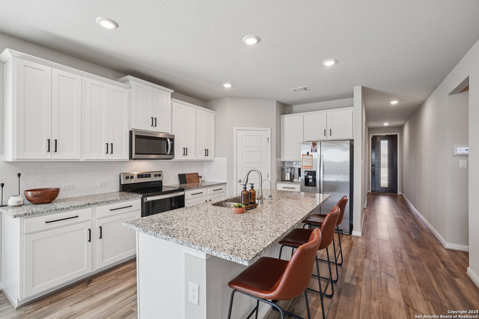 3311 Junction Bay Converse, TX 78109 - Photo 16 of 50 a kitchen with stainless steel appliances granite countertop a kitchen island hardwood floor sink and stove