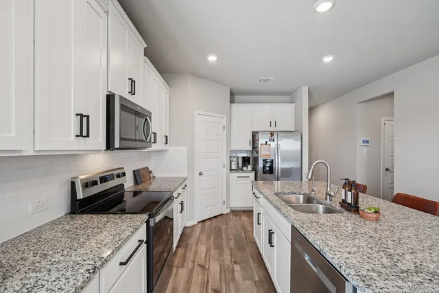 a kitchen with stainless steel appliances granite countertop a sink stove and refrigerator