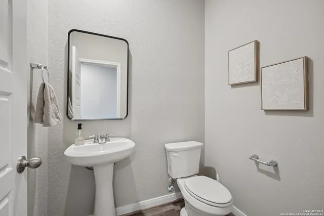 a bathroom with a toilet sink and mirror