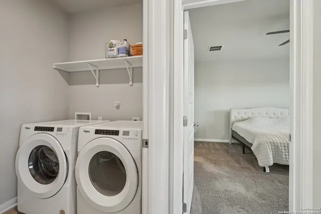 a spacious bedroom with a bed a chandelier and a window