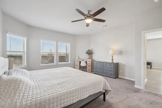 a bedroom with a bed chandelier and a dresser