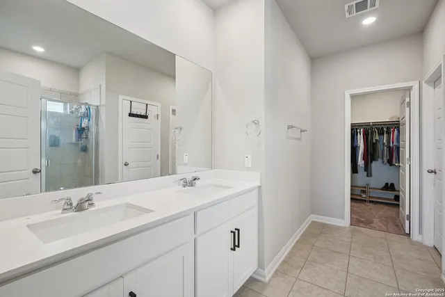 a en suite bathroom with a double vanity sink and mirror