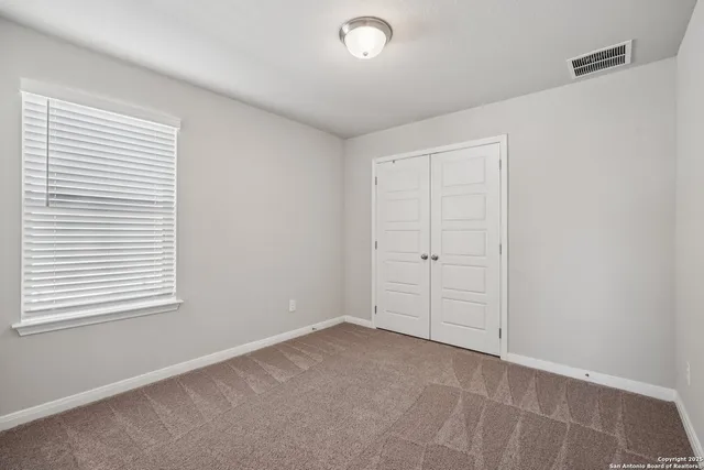 an empty room with windows and closet